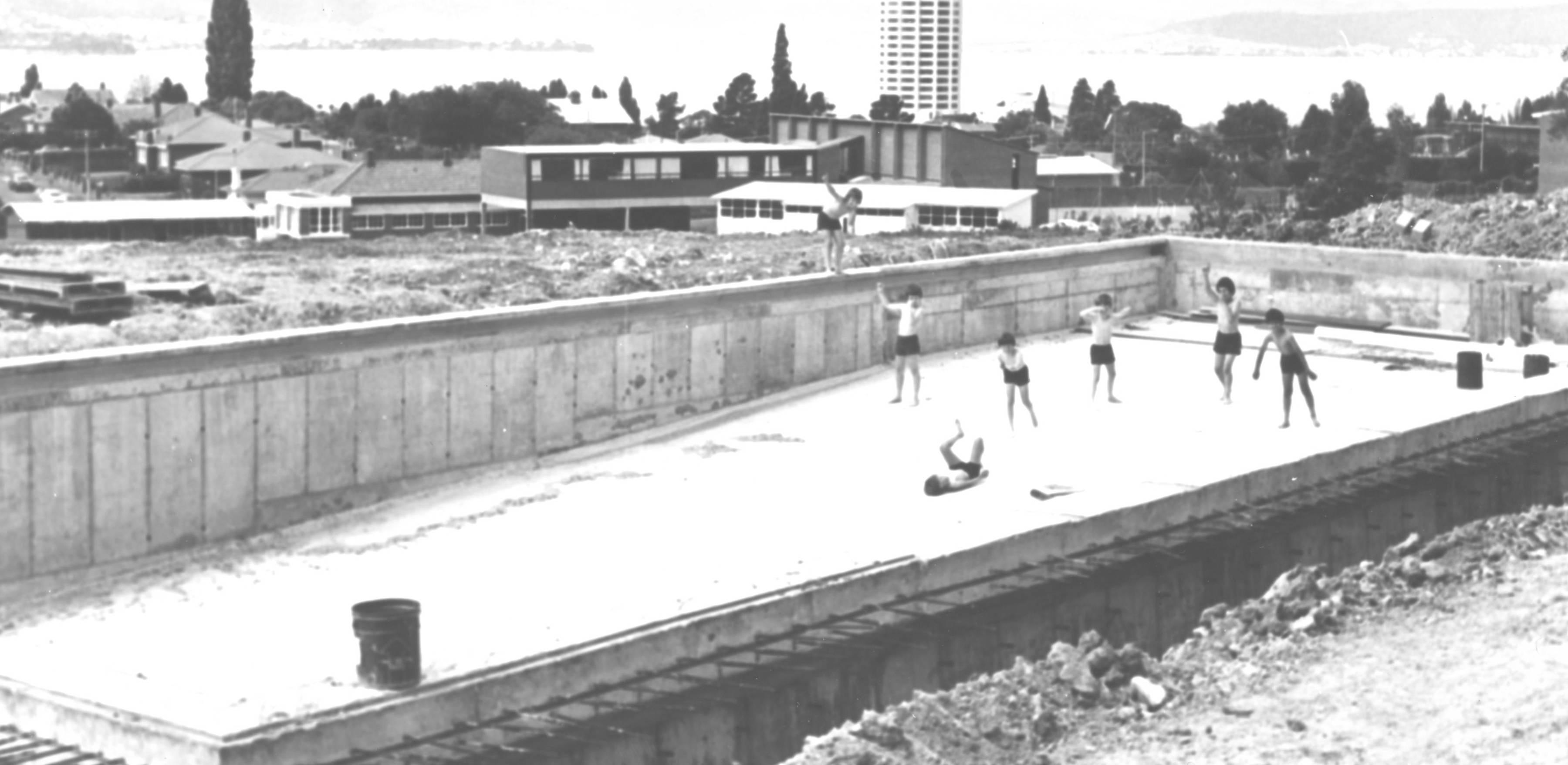 Outdoor swimming pool under construction with ‘swimmers’, 1978.