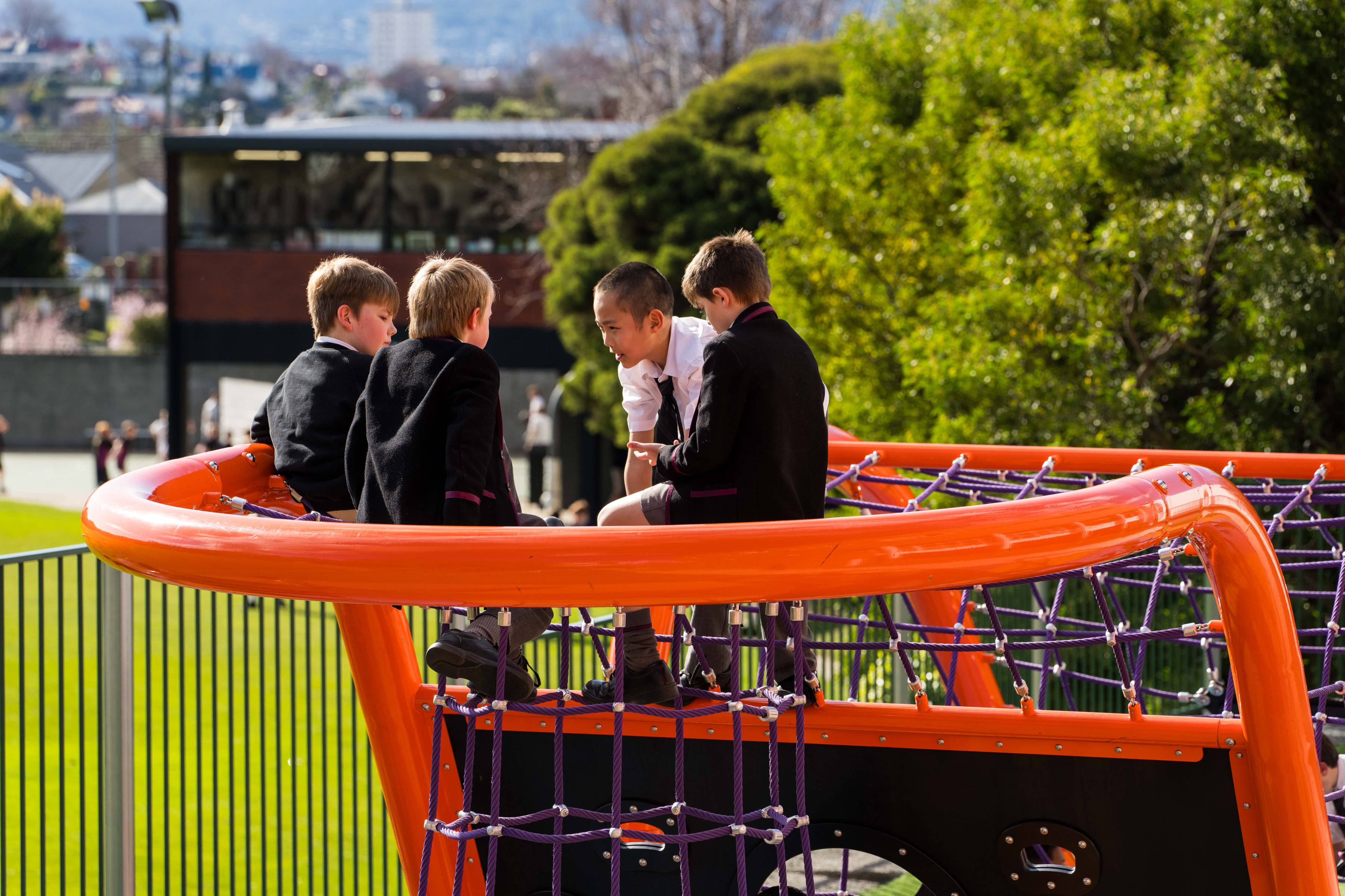 Group of students sitting on rope climbing equipment and chatting. Photo: Joshua Lamont.