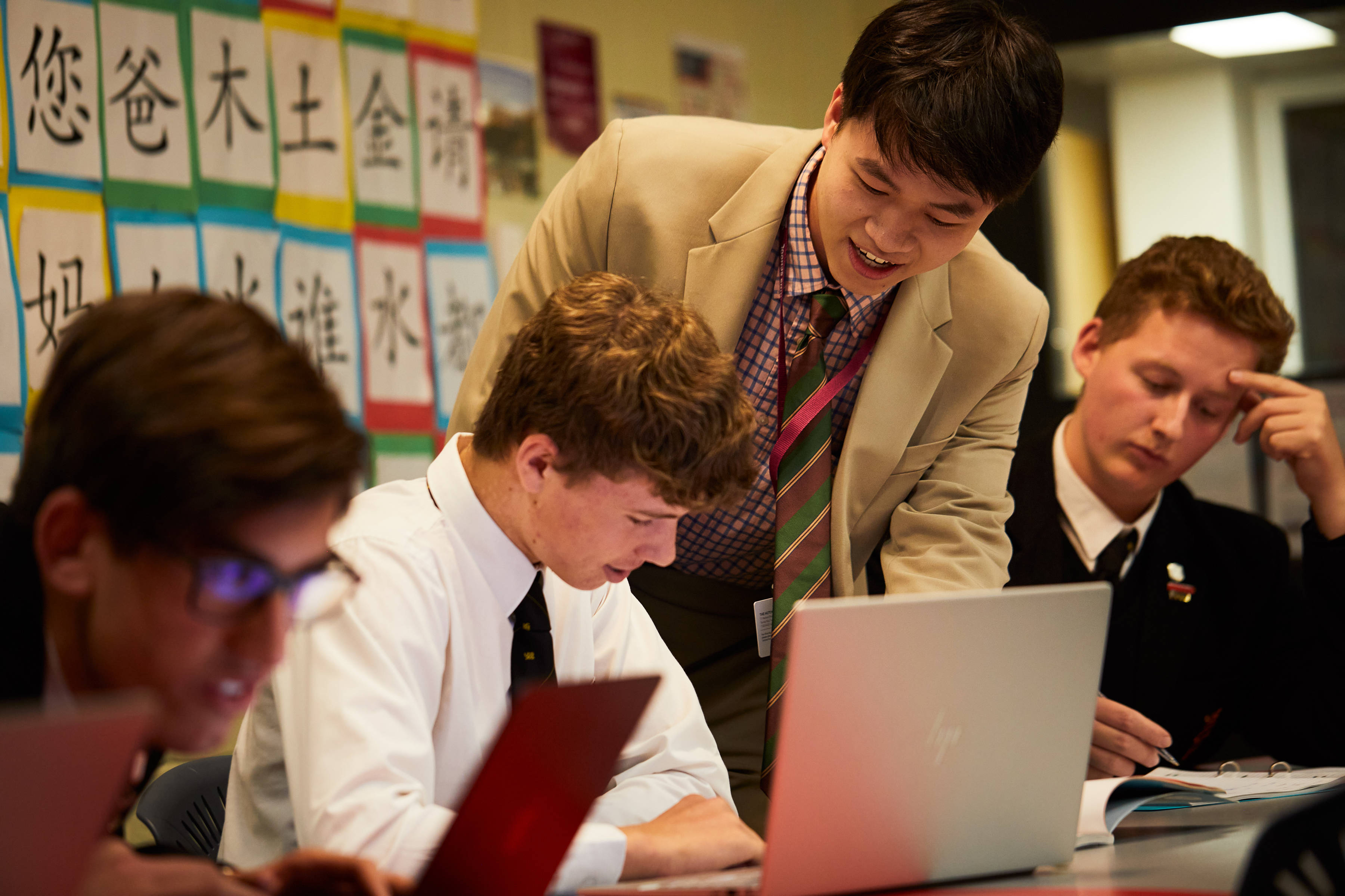 Three Hutchins students in a Japanese class being assisted by a teacher. Photo: Joshua Lamont.